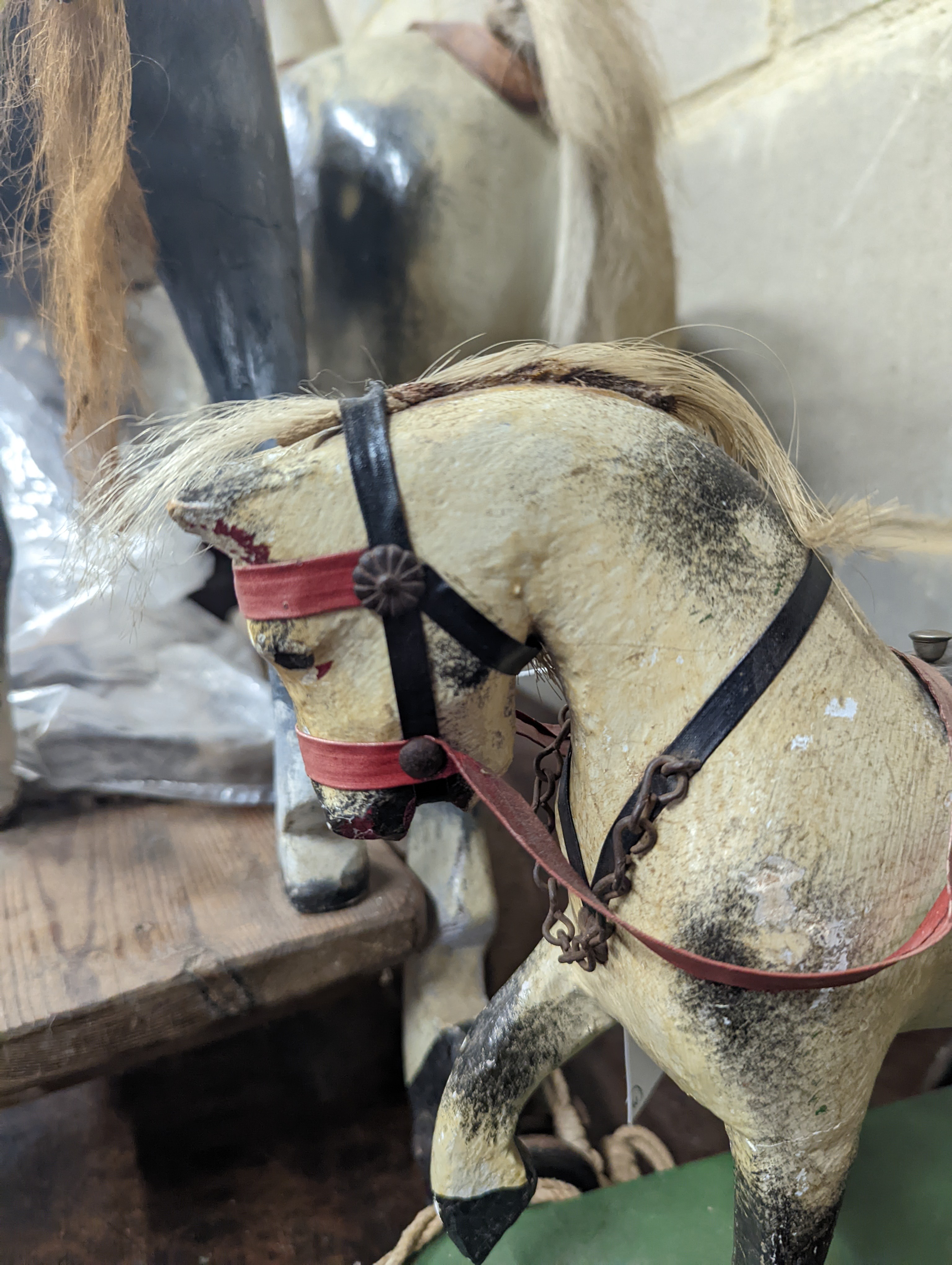 A Victorian carved and painted wood rocking horse, lacking underframe, length 77cm and two painted wood hobby horses, 58cm and 38cm